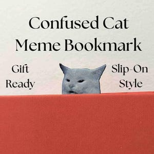 Può includere: Un segnalibro a forma di gatto grigio spunta da un libro rosso. Il testo "Confused Cat Meme Bookmark" è sopra il gatto. Il testo aggiuntivo recita "Gift Ready" e "Slip-On Style."