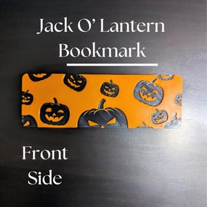 May include: Orange and black Jack O' Lantern bookmark. The bookmark features a repeating pattern of smiling pumpkin faces. The text "Jack O' Lantern Bookmark" is at the top of the image, with "Front Side" at the bottom.