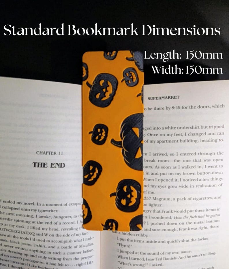May include: Orange bookmark with black jack-o'-lanterns. The bookmark is rectangular, with dimensions of 150mm in length and 150mm in width. Text on the bookmark reads "Standard Bookmark Dimensions". The bookmark is placed in an open book.