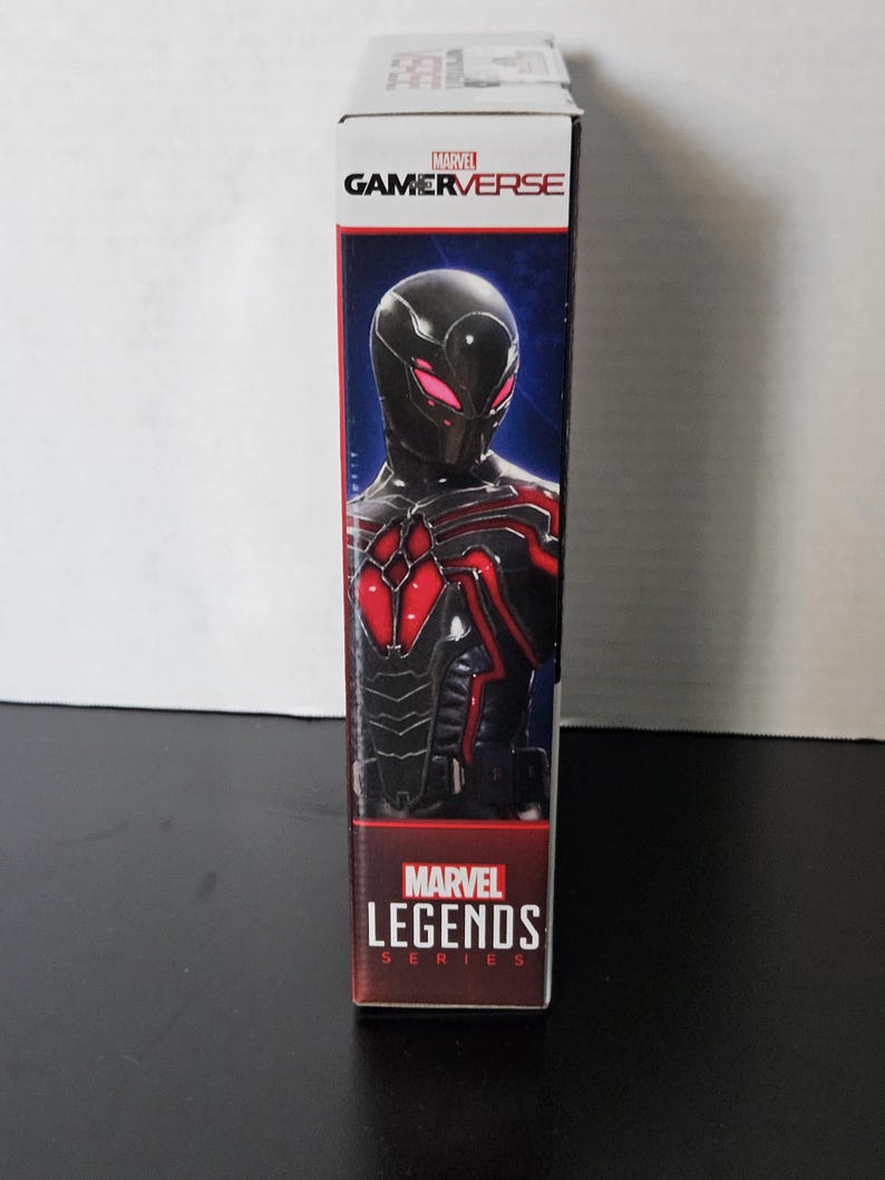 May include: A Marvel Gamerverse action figure box. The box shows a character in a black and red suit with a mask. The Marvel Gamerverse logo is at the top, and the Marvel Legends Series logo is at the bottom.