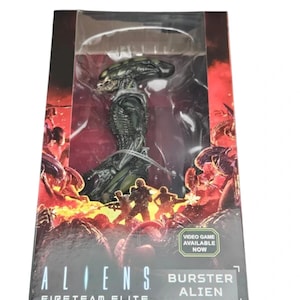 May include: A collectible action figure of a Burster Alien from Aliens Fireteam Elite, encased in a rectangular cardboard box with a clear plastic window. The packaging features fiery red and black graphics and the text Video Game Available Now.
