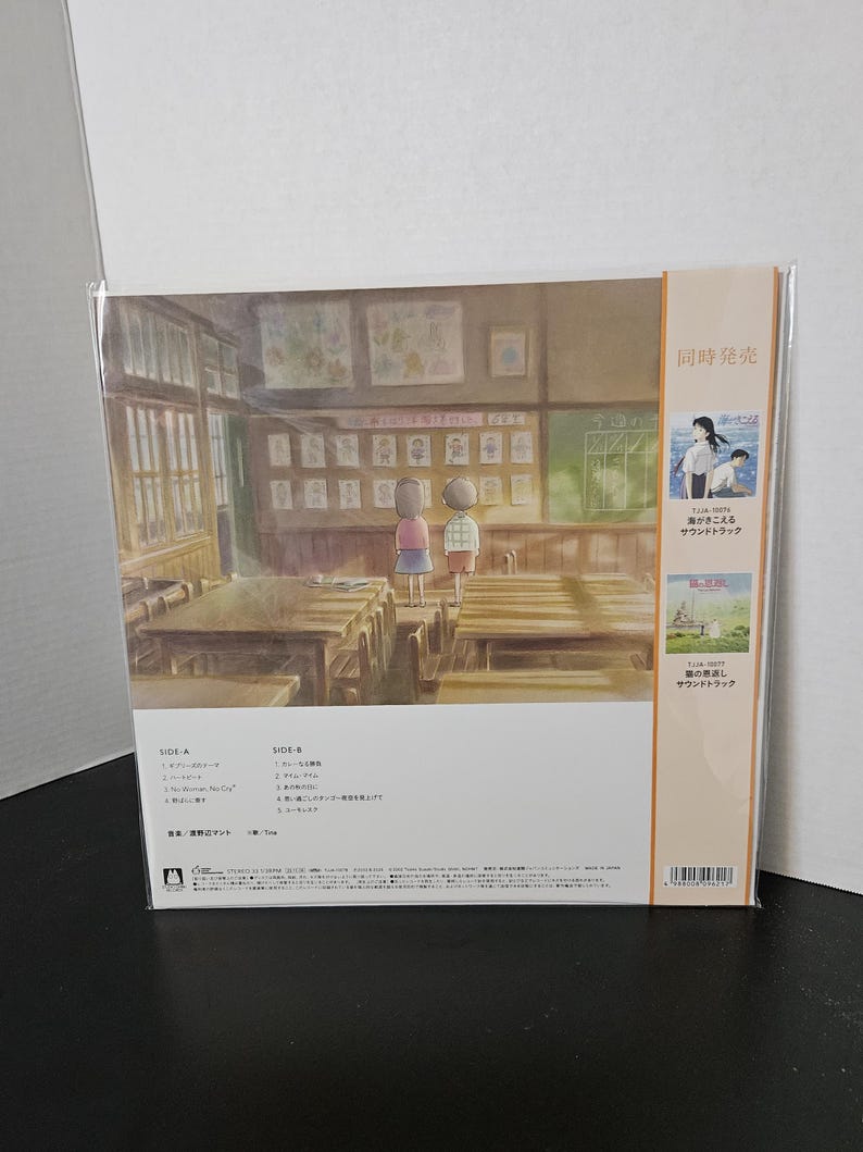 May include: A vinyl record featuring artwork of a classroom scene with two children. The album cover includes Japanese text and a smaller image of a seaside scene. The record is in a clear plastic sleeve.