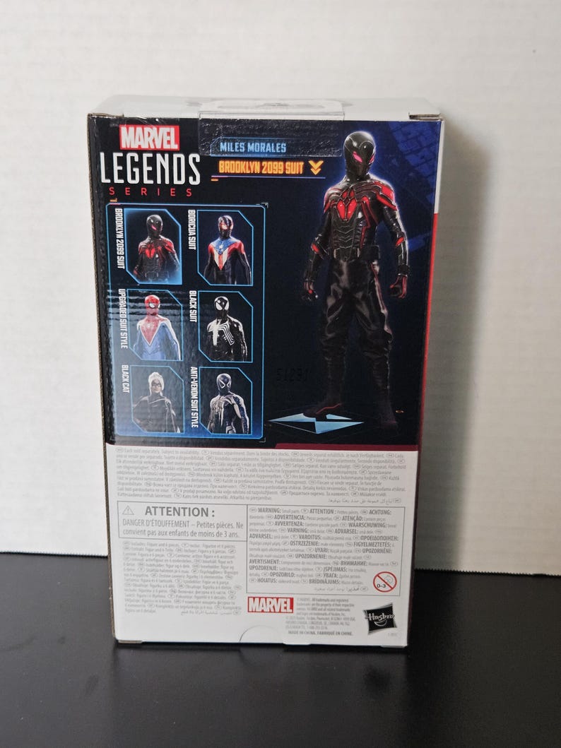 May include: A Marvel Legends Series action figure box featuring Miles Morales in the Brooklyn 2099 suit. The box has images of other suits, including the Boricua Suit and Black Suit. The box is black, red, and white.