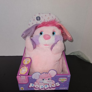 May include: A pink Popples Party plush toy in its original box. The plush has pink fur, purple accents, and sparkly pink ears. The box features the Popples logo and the words "Limited Edition".
