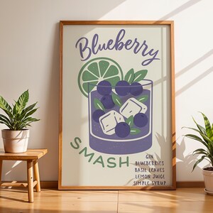 May include: A framed print featuring a Blueberry Smash cocktail illustration. The artwork includes a glass with blueberries, ice cubes, and a lime slice. Text reads "Blueberry Smash" and lists ingredients: gin, blueberries, basil leaves, lemon juice, and simple syrup.