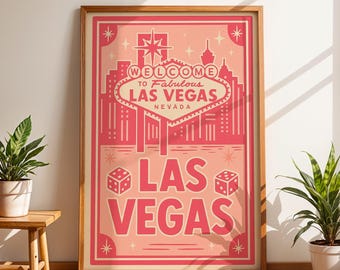 Op de afbeelding: Een ingelijste poster met een roze en rood ontwerp met de woorden "Welcome to Fabulous Las Vegas Nevada". De poster bevat afbeeldingen van dobbelstenen, sterren en een stadsgezicht. De poster wordt weergegeven naast een kleine houten kruk met een potplant.