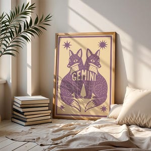 Puede incluir: Impresi&oacute;n art&iacute;stica enmarcada con dos zorros morados enfrentados, con la palabra "GEMINI" entre ellos. La obra de arte est&aacute; sobre un fondo crema con acentos de estrellas. El marco es de color madera clara.