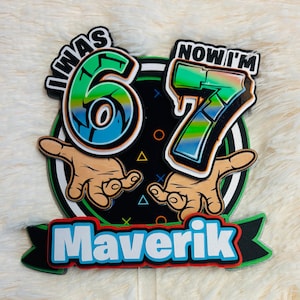 May include: A colorful birthday cake topper with the text "I WAS 6 NOW I'M 7" and the name "Maverik". The design features the numbers 6 and 7 in a graffiti style, with hand illustrations and a black background.