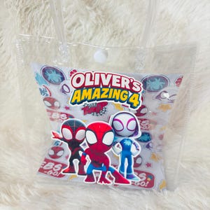 May include: Clear plastic tote bag with a white and patterned insert featuring Spider-Man characters and the text "Oliver's Amazing 4". The bag has a clear handle and a white snap closure.