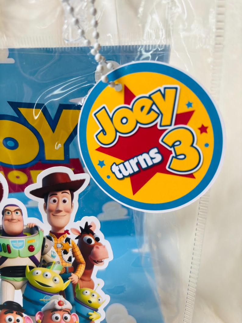 May include: A white ceramic mug with a black handle and the text "But First, Coffee" in a bold, black font. The mug is set against a blurred background, suggesting a cozy setting.