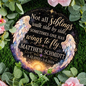 May include: A round memorial stone with the text "Not all siblings walk side by side, sometimes one has wings to fly." The name "MATTHEW SCHMIDTT" and dates 8.12.1992-5.4.2024 are also included. The design features angel wings and a sunset.