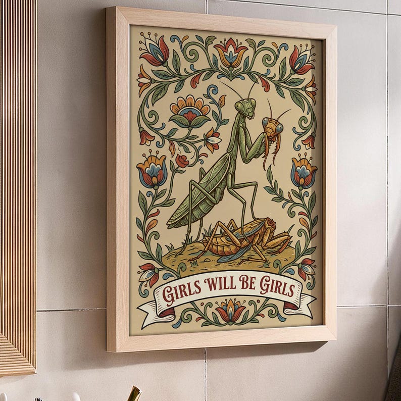 May include: Framed art print featuring a green praying mantis holding a smaller insect, with a second insect below. The artwork is surrounded by floral designs in red, blue, and green, with the text "GIRLS WILL BE GIRLS" on a banner.