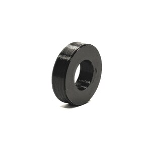 May include: A black, circular object with a hole in the center. The object has a textured surface and appears to be made of a solid material. The object is isolated against a white background.