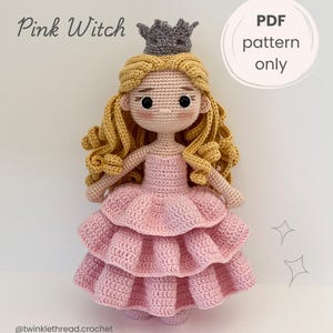 Op de afbeelding: Een gehaakte pop met lang krullend blond haar, een grijze kroon en een roze gelaagde jurk. De tekst luidt Pink Witch en PDF pattern only. De pop heeft zwarte ogen, een kleine neus en roze wangen. Een handgemaakte textielfiguur.