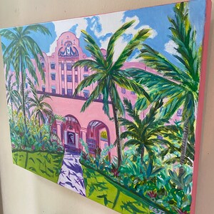 May include: A painting depicting a pink building with palm trees and a pathway in front. The building has white trim and a sign that reads "The Breakers". The painting is signed "K. Jones".