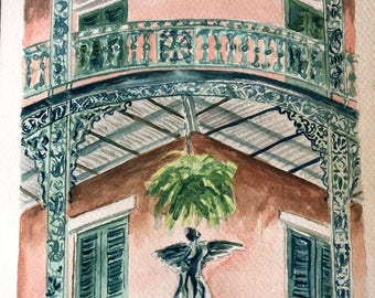 May include: Watercolor painting of a pink building with a green balcony and a green plant hanging from the ceiling. The balcony has an ornate iron railing and a statue of an angel with wings.