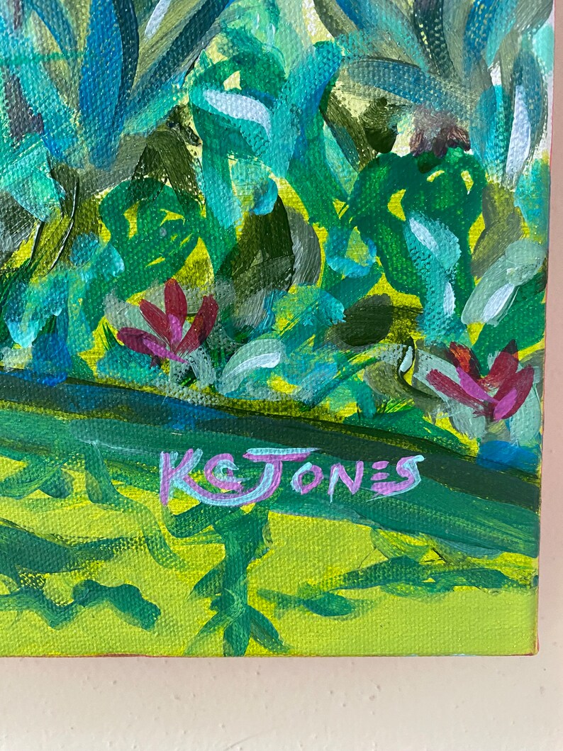 May include: A painting of a green and blue landscape with pink flowers and the artist's signature "K& JONES" in the bottom right corner.