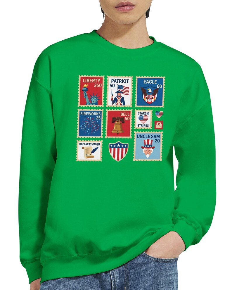 May include: Green sweatshirt with a series of patriotic stamp designs. The stamps show the Statue of Liberty, an American flag, an eagle, fireworks, a bell, stars and stripes, and Uncle Sam. The sweatshirt is made of a soft material.