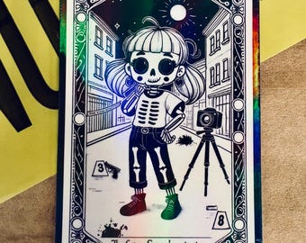 May include: A tarot card illustration of a skeleton character in a crime scene. The character wears a white shirt, black trousers, and mismatched shoes. A camera on a tripod and a gun are also depicted. The card is labelled "The Crime Scene Investigator - Female."