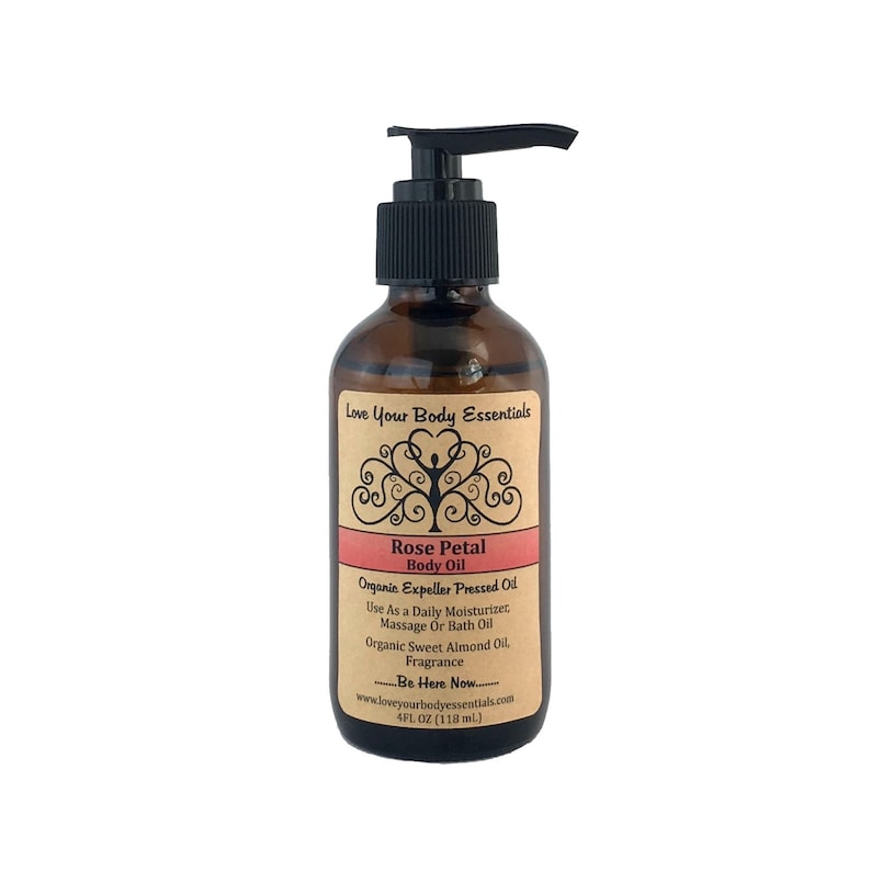 May include: A brown glass bottle of Rose Petal Body Oil with a black pump dispenser. The label features text including "Love Your Body Essentials" and "Rose Petal Body Oil." The bottle contains 4 fl oz (118 mL) of oil.