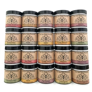 May include: Twenty-four small jars of hand and body cream with various scents, including Lavender, Jasmine, Orange Blossom, and Rose Petal. Each jar has a black lid and a label with a tree design and the brand name "Love Your Body Essentials".