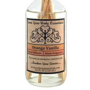 Puede incluir: Una botella de vidrio transparente con una etiqueta marr&oacute;n que dice "Love Your Body Essentials" y "Orange Vanilla Reed Diffuser Home Fragrance". La etiqueta tambi&eacute;n incluye el texto "...Awaken Your Senses..." y "loveyourbodyessentials.com". La botella contiene un l&iacute;quido transparente y tiene palitos de madera insertados en ella. La botella tiene una capacidad de 4,0 fl oz (118 ml).
