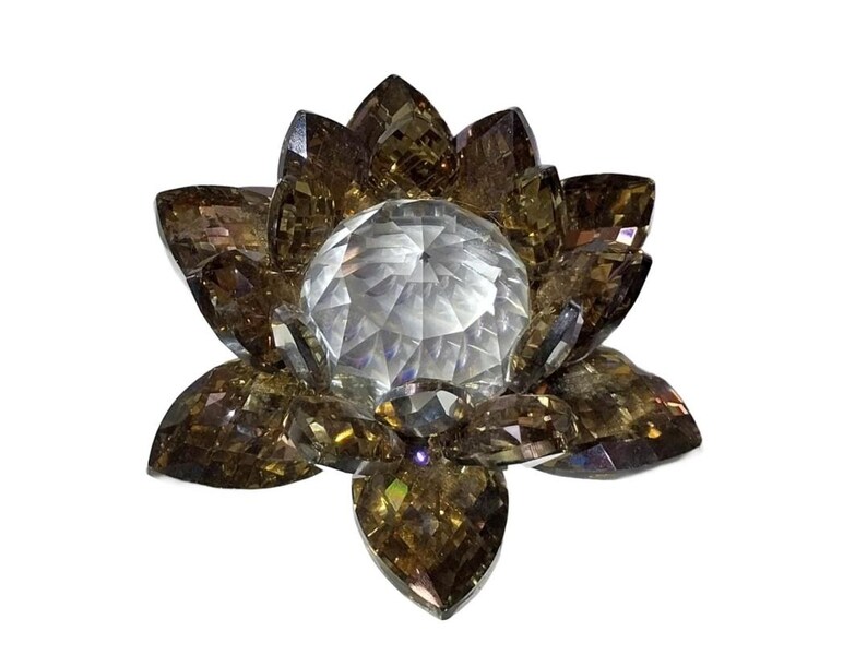 May include: A decorative crystal lotus flower with faceted petals in shades of brown and a central clear crystal sphere. The flower is designed to catch and reflect light, creating a sparkling effect.