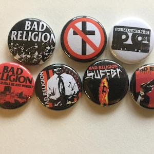 May include: Seven round black and white buttons with the band name "Bad Religion" and various album covers and logos. The buttons feature red, white, and black colors.