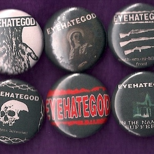 May include: Six black and white button pins with the band name "EYEHATEGOD" printed in white. The pins feature different designs, including a hand, a person, guns, a skull, a band name, and a building.