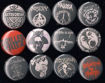 May include: A collection of 12 round, black and white buttons with various band names and logos. The buttons feature a variety of designs, including skulls, peace signs, and text. The buttons are all approximately 1 inch in diameter.
