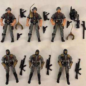 May include: Collection of action figures in gray and black uniforms with helmets. Each figure has a different accessory, including guns, a radio, and a helmet. The figures are standing upright, and the accessories are scattered around them.