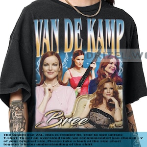 May include: Black unisex t-shirt with a graphic of the character Bree from "Desperate Housewives." The design includes the text "VAN DE KAMP" and "Bree" with images of the character. The shirt is regular fit and available in 2XL.