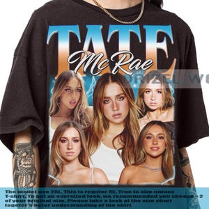 Puede incluir: Camiseta unisex negra con el nombre "Tate McRae" en un dise&ntilde;o degradado azul y naranja. La camiseta muestra m&uacute;ltiples im&aacute;genes de Tate McRae. El texto en la parte inferior de la camiseta dice "The model use 2XL..."