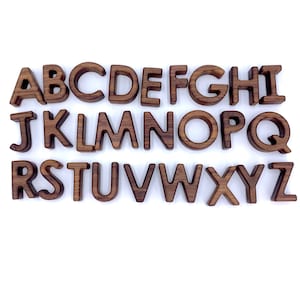 May include: Wooden alphabet letters in a brown color. The letters are arranged in alphabetical order from A to Z.