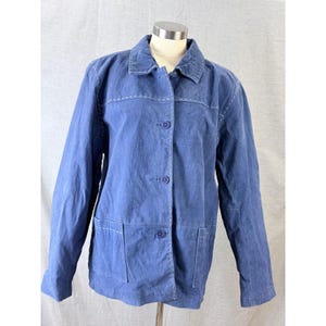 May include: A blue jacket with a button-up front, two front pockets, and a collar. The jacket has white stitching details along the seams and around the collar. The jacket is displayed on a mannequin.