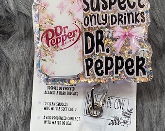 Suspect only drinks Dr. pepper, fun glitter retractable badge reel or magnet. Gift for teacher-student-co worker-nurse- medical staff-soda