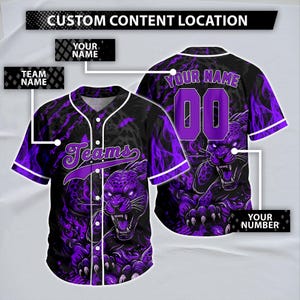 May include: A black and purple baseball jersey featuring a graphic of a snarling panther and flame patterns. The front displays the word Teams, while the back includes placeholders for Your Name and 00, with labels for custom content location.