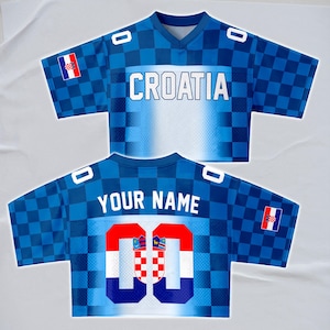 May include: A blue and white Croatian soccer jersey with the word "CROATIA" across the chest. The jersey has a checkered pattern and the number "00" on the back. The Croatian flag is displayed on the sleeves.