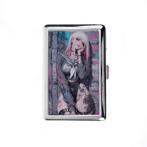 Pode incluir: Um porta-cigarros de metal prateado com uma ilustração em estilo anime. A obra de arte retrata uma pessoa com cabelo branco e reflexos rosa, vestindo um top cinza em estilo marinheiro. O fundo inclui grafite.