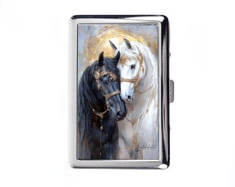 Pode incluir: Um porta-cigarros prateado com uma pintura de dois cavalos. Um é preto, o outro branco, ambos adornados com rédeas douradas. A obra de arte tem um estilo suave e pictórico com um efeito de halo dourado.