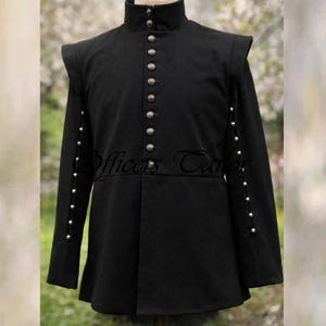 Puede incluir: Chaqueta negra de estilo militar con cuello alto y botones plateados decorativos. Las mangas largas tienen detalles de botones plateados. La chaqueta tiene hombreras y un bajo ligeramente acampanado. El texto "Officers Tailor" es visible.