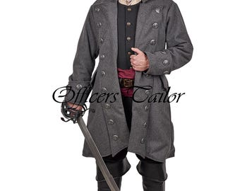Könnte beinhalten: Ein langer anthrazitfarbener Mantel mit zweireihigen silbernen Knöpfen, getragen über einer schwarzen Weste, einem beigen Hemd mit Kragen und einer kastanienbraunen Schärpe. Das Outfit umfasst schwarze Hose und Stiefel sowie ein Schwert. Text Officers Tailor.