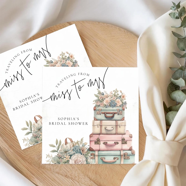 May include: Bridal shower invitation featuring a stack of vintage suitcases in pastel colors, topped with flowers. The text reads "Traveling from Miss to Mrs" and "Sophia's Bridal Shower". The design includes floral accents.