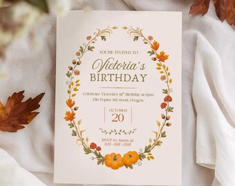 Può includere: Un invito di compleanno color crema con un design a ghirlanda floreale ovale. Il testo recita "Victoria's Birthday" e include la data "20 ottobre". Foglie autunnali e zucche decorano la carta, con foglie aggiuntive sparse.