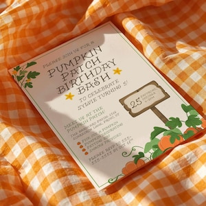 May include: A fall-themed invitation for a pumpkin patch birthday bash. The invitation features text, pumpkins, and leaves, with the date and time of the event. The invitation is set on an orange and white checkered fabric.