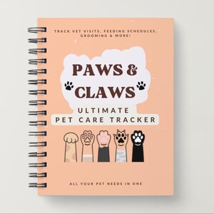 Könnte beinhalten: Ein spiralgebundenes Haustierpflege-Notizbuch mit pfirsichfarbenem Einband. Der Einband zeigt den Text "PAWS & CLAWS" über "ULTIMATE PET CARE TRACKER". Darunter sind illustrierte Tierpfoten. Der Text "TRACK VET VISITS, FEEDING SCHEDULES, GROOMING & MORE!" steht oben.