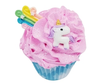 May include: A decorative cupcake with pink frosting and a blue cupcake liner. The frosting is topped with a white unicorn figurine with purple hair and a gold horn, and a rainbow and star accent.