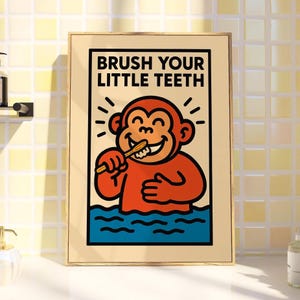 May include: A framed poster featuring the text "BRUSH YOUR LITTLE TEETH" and a cartoon monkey brushing its teeth. The monkey is orange and smiling, standing in blue water. The frame is gold-coloured.