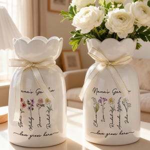 Puede incluir: Una taza de cerámica blanca con un asa negra y el texto "But First, Coffee" en negrita negra. La taza está sobre una superficie blanca. La taza mide aproximadamente 10 cm de alto.