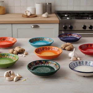 Puede incluir: Colección de ralladores de ajo de cerámica coloridos con diseños florales. Los ralladores son de varios colores, incluyendo naranja, verde, azul y rojo. Ajos y jengibre sugieren uso culinario.